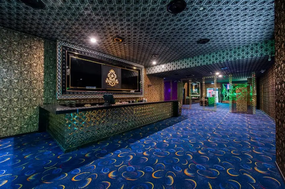D'Arc Club Ampang (凯旋门): reception counter with the D'Arc Club logo screen, patterned walls and blue swirl carpet leading to a neon-lit corridor