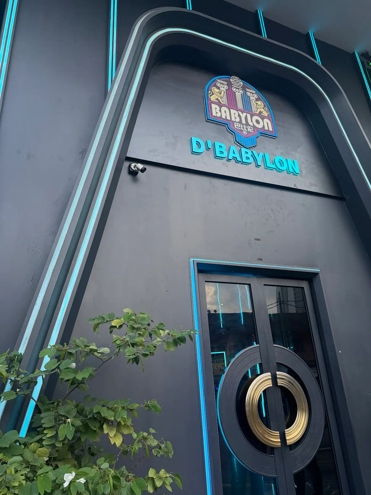 D Babylon Club: Building entrance with illuminated D'Babylon sign and round-handled door